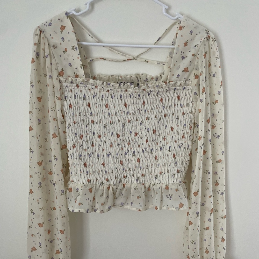 Cute smocked top with sheer sleeves.